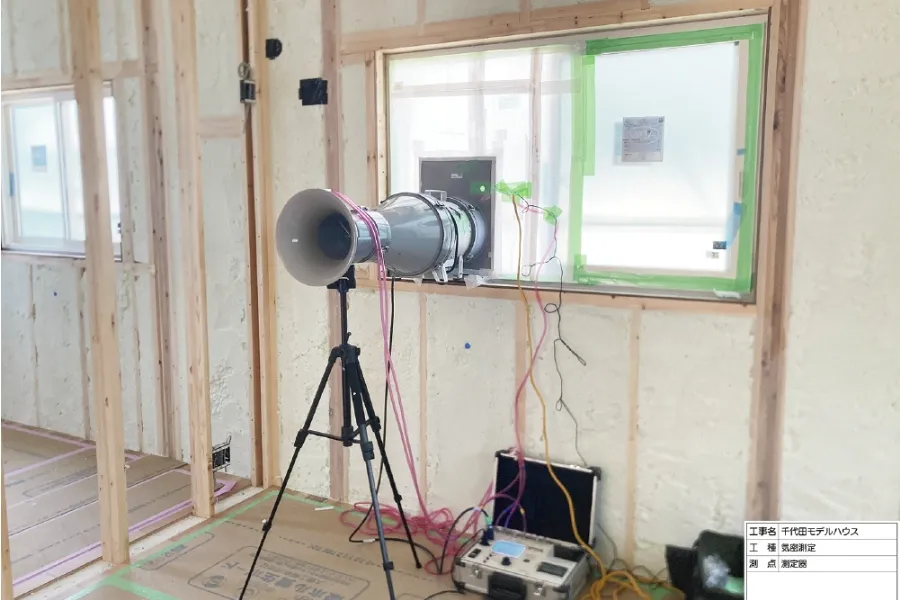 気密測定の様子。機械を使って住宅の気密性能を測定している風景